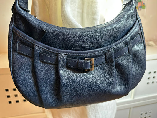 Longchamp Sac cuir bleu marine porté épaule.