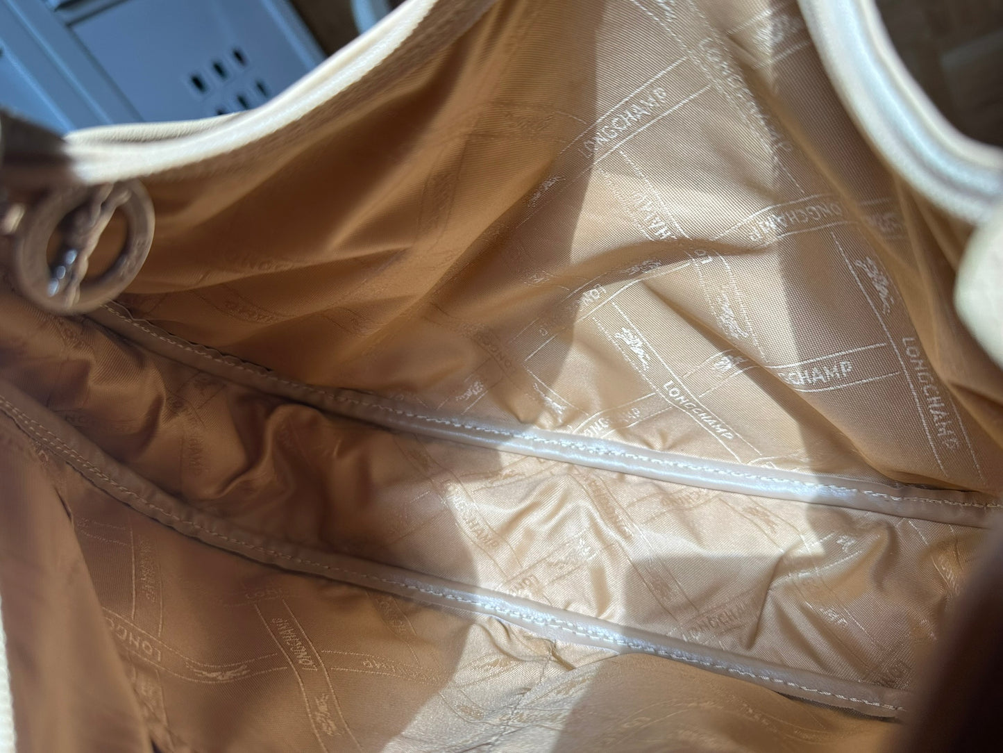 Longchamp Sac cuir beige porté épaule.