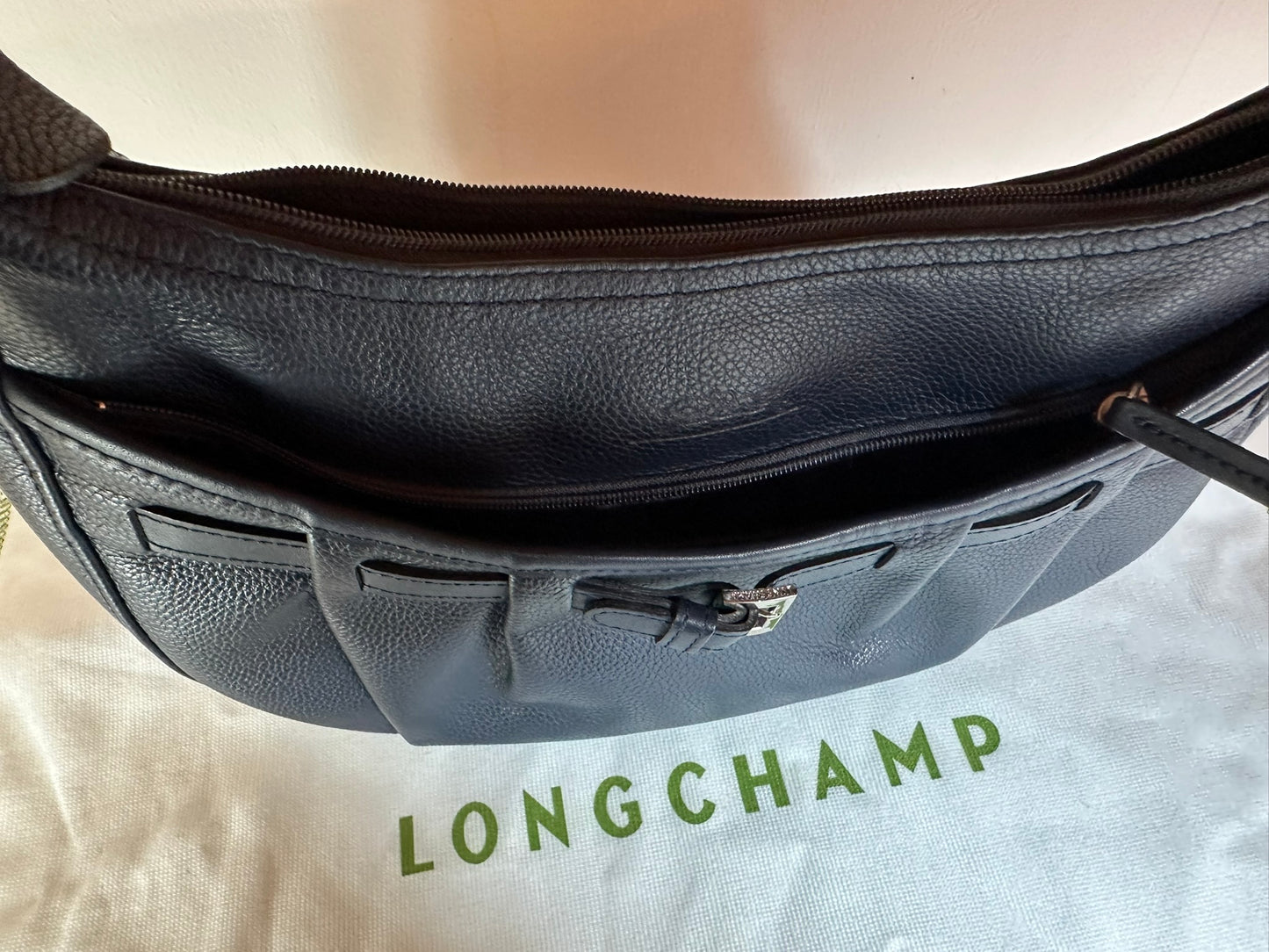 Longchamp Sac cuir bleu marine porté épaule.