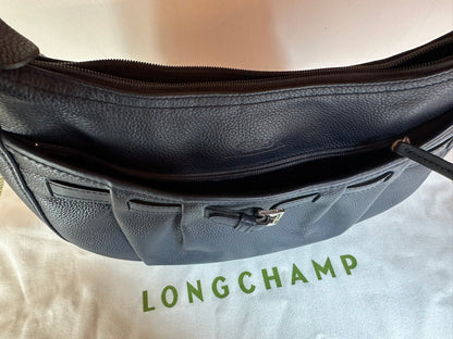 Longchamp Sac cuir bleu marine porté épaule.