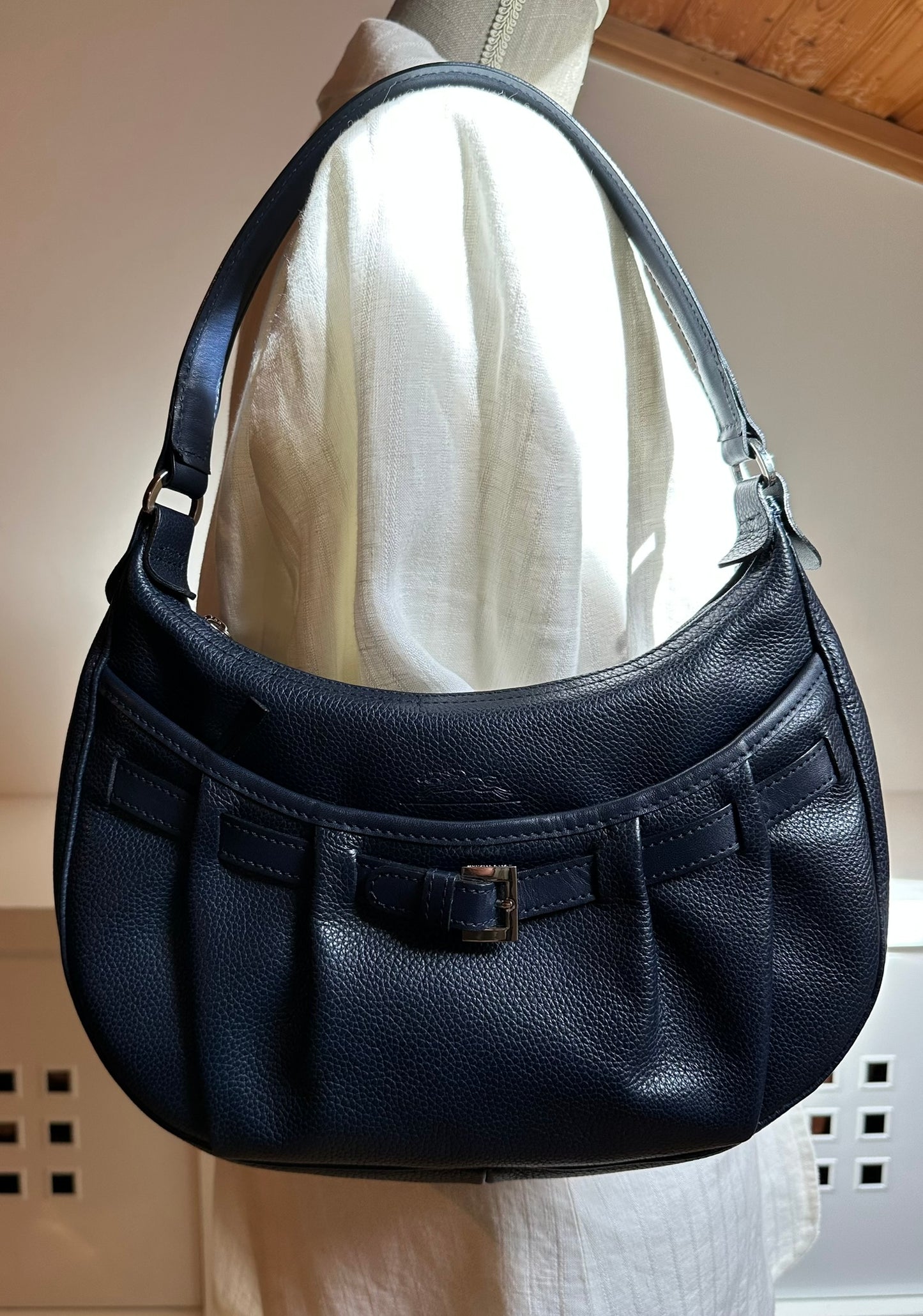 Longchamp Sac cuir bleu marine porté épaule.