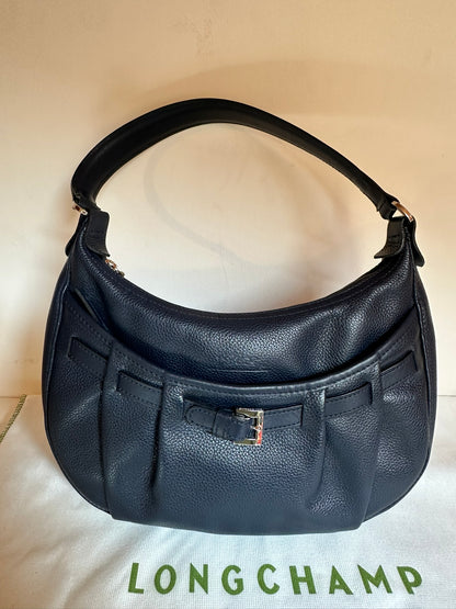 Longchamp Sac cuir bleu marine porté épaule.