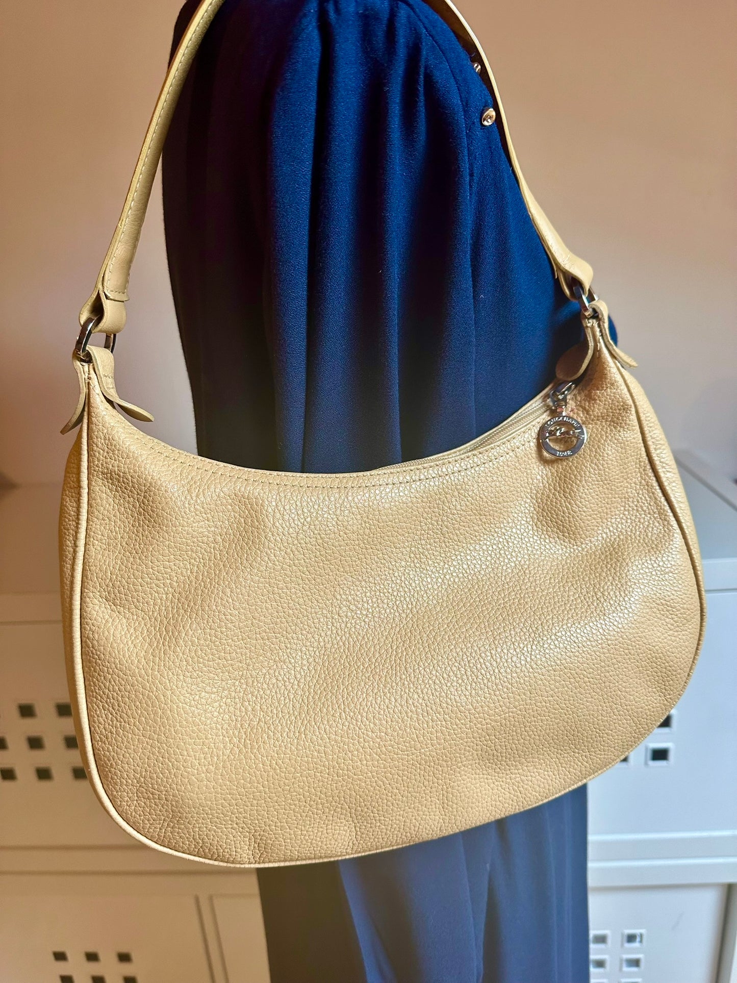 Longchamp Sac cuir beige porté épaule.